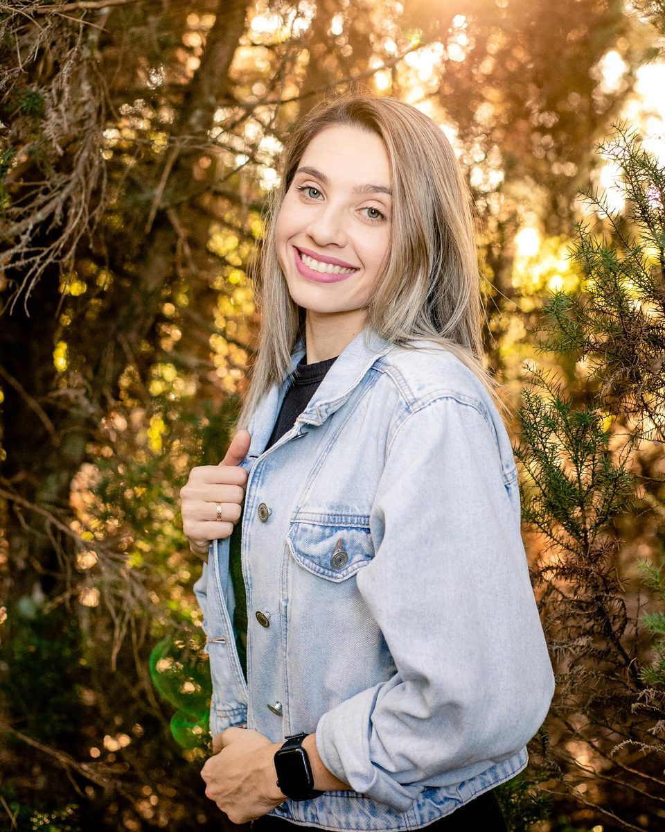 Micheli Aguirres, nutricionista, sorrindo com jaqueta jeans